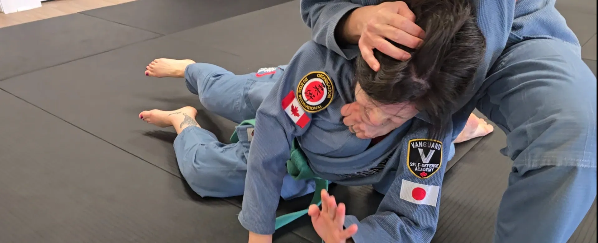 Adult students practising a self-defense technique together at Vanguard Self-Defense Academy