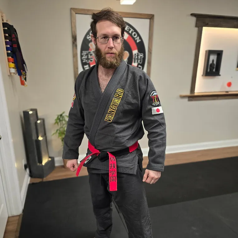 Vanguard instructor in a black gi standing inside the Chesterville dojo